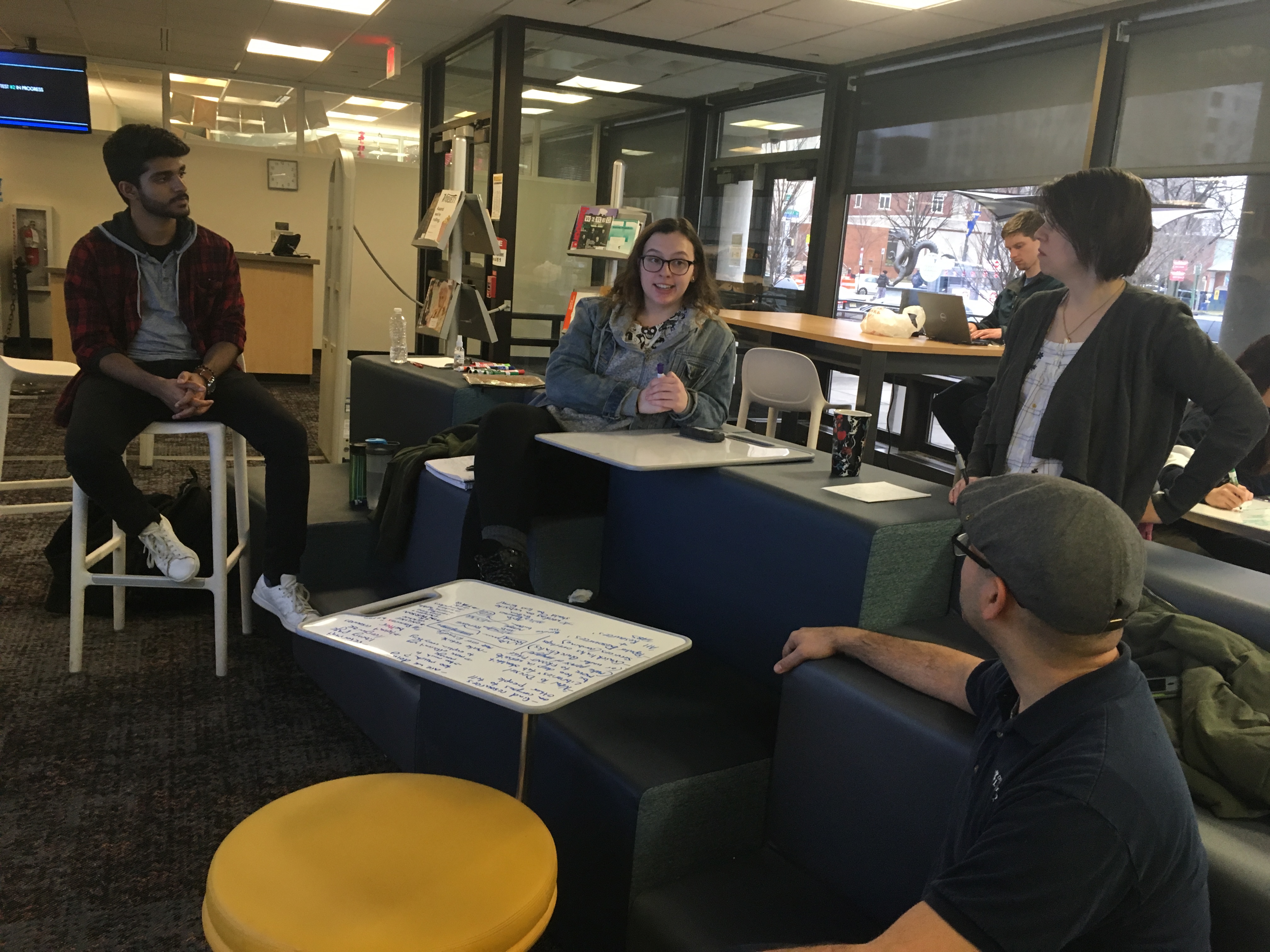 Two men and two women talking in the Dragons' Learning Den.